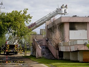 Firefighters hose down hot spots at a vacant building fire located at 132 Avenue and 114 Street in Edmonton on Monday May 31, 2021. The fire started at approximately 3 a.m. Fire investigators were on scene.
