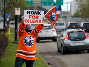Edmonton Oilers fan Tanya Hamilton, an employee at United Sport and Cycle, gets into the playoff spirit outside the sporting goods store in Edmonton on Tuesday May 11, 2021.