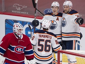 Edmonton Oilers forward Ryan Nugent-Hopkins (93) celebrates his goal with teammates Leon Draisaitl (29) and Kailer Yamamoto (56) after scoring the second goal on Montreal Canadiens goaltender Jake Allen (34) during first period NHL hockey action in Montreal, Monday, May 10, 2021.
