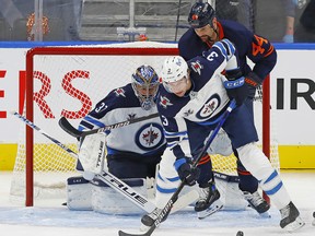 Edmonton Oilers forward Zack Kassian (44) battles for a loose puck against Winnipeg Jets defencemen Tucker Poolman (3) in front of  goaltender Connor Hellebuyck (37) during Game 1 of their first round of the 2021 Stanley Cup Playoff series at Rogers Place.