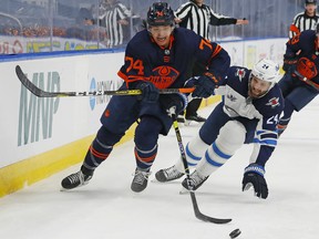 Edmonton Oilers defencemen Ethan Bear (74) and Winnipeg Jets defencemen Derek Forbort (24) chase a loose puck during their first-round Stanley Cup playoff series at Rogers Place on May 19, 2021.