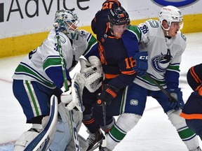 Edmonton Oilers James Neal (18) gets sandwich between Vancouver Canucks Nate Schmidt (88) and goalie Thatcher Demko (35) during NHL action at Rogers Place in Edmonton, May 6, 2021.