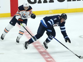Winnipeg Jets forward Andrew Copp (right) is slowed by Edmonton Oilers defenceman Darnell Nurse during Game 4 of their Stanley Cup playoff series in Winnipeg on Monday, May 24, 2021