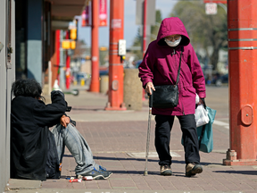A woman walks on 97 Street  in Edmonton's downtown Chinatown district on Monday May 10, 2021.