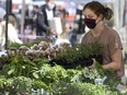 Georgia Simkin helps set up the Reclaim Organics booth in preparation for the opening evening of the 124 Grand Market.