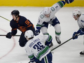 The Edmonton Oilers Kailer Yamamoto (56) battles the Vancouver Canucks' Nils Hoglander (36), Jack Rathbone (3), and Brock Boeser (6) during first period NHL action at Rogers Place, in Edmonton Saturday May 8, 2021. Photo by David Bloom
