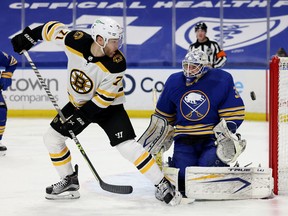 Boston Bruins winger Taylor Hall deflects a shot on Buffalo Sabres goaltender Dustin Tokarski during NHL action on April 22, 2021.