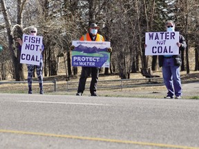 A group of Foothills residents who are against coal development along the Eastern Slopes hold up signs along Highway 2 south of Nanton,