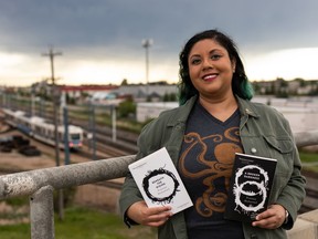 Science fiction/horror author Premee Mohamed holds her books Beneath The Rising and A Broken Darkness, announcing the third title of this trilogy will be published in March 2022.