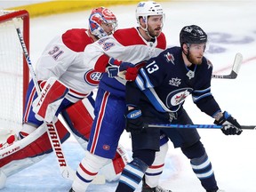Pierre-Luc Dubois #13 of the Winnipeg Jets jockeys for space in front of Joel Edmundson #44 and Carey Price #31 of the Montreal Canadiens in Game Two of the Second Round of the 2021 Stanley Cup Playoffs on June 4, 2021 at Bell MTS Place in Winnipeg, Manitoba, Canada.