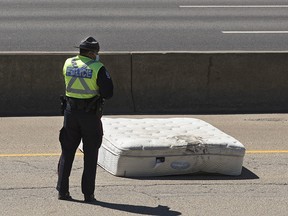 Police continue to investigate on the west bound Whitemud Drive between 66 Street and 91 Street, Saturday June 12, 2021, where a motorcyclist was injured after a mattress knocked him off his bike.