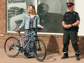 Carrie Candy and Edmonton Police Service Detective Dana Gehring, pose for a photo with her daughter's bicycle outside United Sport and Cycle, 7620 Gateway Blvd., in Edmonton Tuesday June 22, 2021. The bicycle had been stolen during a garage break and enter in Edmonton and was found in Vancouver ten days later. On Tuesday the bicycle was returned to its owners.