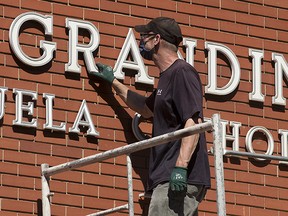 Crews from Edmonton Catholic Schools remove the Grandin name from Grandin Elementary School, 9844 110 St., in Edmonton Monday June 28, 2021. Monday morning Edmonton Catholic School Board trustees unanimously voted to rename the school and remove a mural of Bishop Vital Grandin from the exterior of the school. Grandin was an advocate for the Indigenous residential school system.
