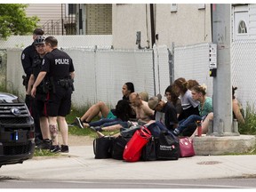 Police have a group of people handcuffed on the ground at the corner of 97 Street and 109 A Avenue on Friday, June 4, 2021 in Edmonton.