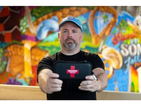 Darren McGeown with Arcadia Brewery holds a naloxone kit the brewery has on hand as it participates in the Each + Every harm reduction initiative in Edmonton on Friday, June 18, 2021. McGeown's business is part of a group of Edmontonians and Calgarians acting to protect their communities during the growing opioid crisis.