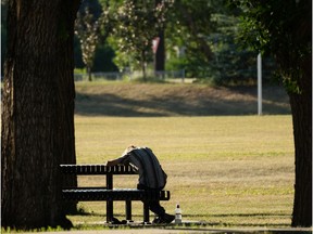 A man sleeps at a picnic table in Borden Park as the temperature hit 38 degrees Celcius in Edmonton, on Wednesday, June 30, 2021. Photo by Ian Kucerak