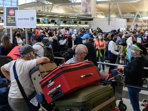 Travelers wait in line at John F. Kennedy Airport ahead of Memorial day weekend on May 28, 2021 in New York City.