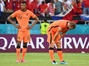 Netherlands defenders Denzel Dumfries (L) and Stefan de Vrij react after losing the UEFA EURO 2020 round of 16 football match between the Netherlands and the Czech Republic at Puskas Arena in Budapest on June 27, 2021.