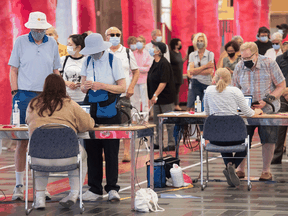 People eligible for a second COVID-19 vaccination shot wait in line at the Palais des congrès vaccination site in Montreal on June 6, 2021.