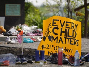 Hundreds of children's shoes remain in place at a memorial outside the Alberta Legislature building in Edmonton on Monday May 31, 2021. A vigil was held Sunday May 30, 2021 in memory of the 215 indigenous children whose remains were discovered on the grounds of a former Roman Catholic church residential school in Kamloops, B.C.