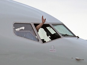 A hand waves from the cockpit of Flair Airlines' new Boeing 737 MAX 8 aircraft as the inaugural flight lands at Edmonton International Airport on Thursday June 10, 2021. It was the first of 13 new Boeing 737 MAX 8 aircraft that Flair Airlines is adding to its fleet. (PHOTO BY LARRY WONG/POSTMEDIA)