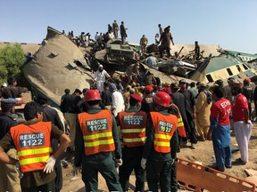 escue workers stand as people gather at the site following a collision between two trains in Ghotki, Pakistan June 7, 2021. REUTERS/Stringer