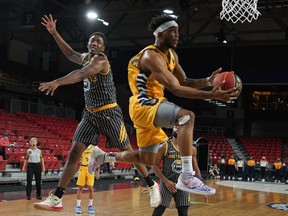 Edmonton Stingers guard Mathieu Kamba (right) evades a block from Hamilton Honey Badgers forward Kalif Young during Canadian Elite Basketball League game action at the Edmonton Expo Centre on Saturday June 26, 2021.
