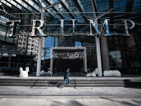 A pedestrian walks past boarded up doors at the closed Trump International Hotel Vancouver, in Vancouver.