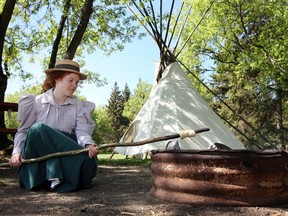 An interpreter wearing period costume bakes bannock over an open fire at Dunvegan Provincial Park, on the banks of the Peace River. The park is on the site of the oldest building in Alberta. File photo.