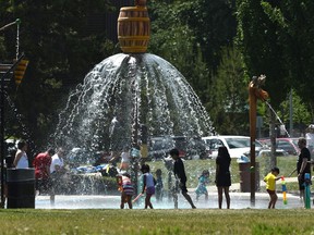 Children enjoying the falling water at the Kinsmen Spray Park in Edmonton, June 20, 2021.