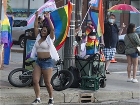 People dance and wave rainbow flags in front of street preachers at the corner of 104 Street and Jasper Avenue, in Edmonton Friday June 4, 2021. Photo by David Bloom