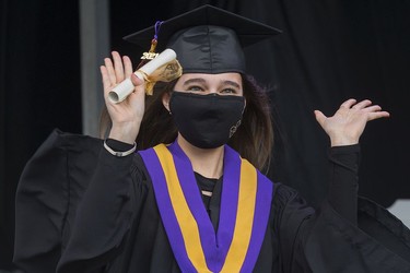 A student celebrates after receiving their diploma during Archbishop MacDonald High School's drive-in graduation ceremony, at the Edmonton EXPO Centre parking lot Friday June 4, 2021. The unorthodox ceremony was in response to COVID-19 health restrictions.