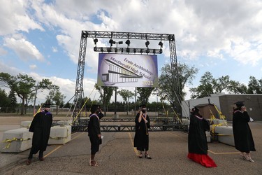 Students wait to walk across the stage and receive their diplomas during Archbishop MacDonald High School's drive-in graduation ceremony, at the Edmonton EXPO Centre parking lot Friday June 4, 2021. The unorthodox ceremony was in response to COVID-19 health restrictions.