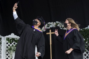 A student stops to take a selfie after receiving their diploma, during Archbishop MacDonald High School's drive-in graduation ceremony, at the Edmonton EXPO Centre parking lot Friday June 4, 2021. The unorthodox ceremony was in response to COVID-19 health restrictions.
