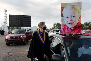 Will Decorby, 18, is greeted with a giant baby photo held up by his family after receiving his diploma at Archbishop MacDonald High School's drive-in-graduation ceremony, at the Edmonton EXPO Centre parking lot Friday June 4, 2021. The unorthodox ceremony was in response to COVID-19 health restrictions.