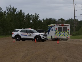 An ambulance drives away from a police blockade west of Edmonton on Saturday, June 5, 2021. Two brothers are facing a slew of charges for a shootout with Edmonton police.