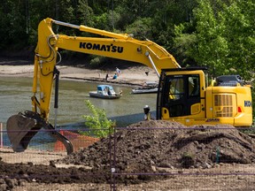 As work continues under the Tawatinâ Bridge people relax across the river at accidental beach on Tuesday, June 1, 2021 in Edmonton. Greg Southam-Postmedia