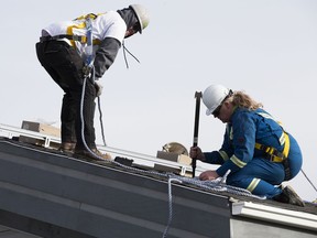 Crews install solar panels on the Louis Bull Daycare as part of a week-long retraining program for energy workers, on the Louis Bull Tribe of the Maskwacis Nation on Friday, Oct. 20, 2017. The training program is part of the Solar Skills campaign by Iron and Earth, a nonprofit association representing oilsands workers.