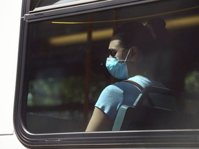 A passenger on a Calgary Transit bus rider wears a mask and looks out the window in Calgary on Friday, June 25, 2021.