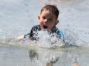 Riders Cole Dorosh, 4, and his uncle Shane Tychkowsky (not shown) refreshed on a hot day on the slip-n-slide put on by the Riverdale Community League as part of their Canada Day celebrations in Edmonton, on Thursday, July 1, 2021. Photo by Ian Kucerak