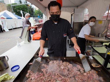 Michael Domingo makes sesame beef with rice at the Japanese Village booth during the opening day of Taste of Edmonton, in Sir Winston Churchill Square Thursday July 22, 2021. Taste of Edmonton runs from July 22 to August 1. Photo by David Bloom