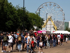 Fair fans lineup before the gates open on the Summer Fun Midway at the Edmonton Expo Centre grounds, on Friday, July 23, 2021.