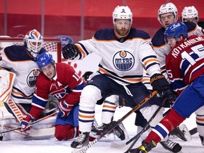 Montreal Canadiens right wing Brendan Gallagher (11) crashes into Edmonton Oilers goaltender Mikko Koskinen (19) after taking a hit from Edmonton Oilers defenseman Adam Larsson (6) as Montreal Canadiens center Jesperi Kotkaniemi (15) tries to recover the rebound during NHL action in Montreal on Tuesday, March 30, 2021.