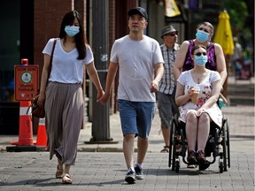 Pedestrians walk on Whyte Avenue in Edmonton on Friday, July 2, 2021. Even though the Alberta government lifted face mask restrictions in the province on July 1, 2021, many people are still choosing to wear face masks in public.