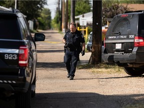Edmonton Police Service officers take evidence in an alley off 102 Avenue and 152 Street where a man was injured by a gunshot and later died of his injuries in Edmonton, on Saturday, July 3, 2021.
