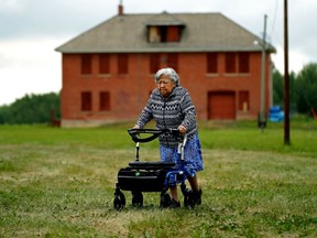 Myrtle Calahaisn, 89, walks across a field in front of a building that used to be part of a residential school in Sturgeon County. She was attending the Poundmaker's survivor gathering on the grounds of the Poundmaker's Lodge Treatment Centre on Tuesday July 6, 2021. The ground she was walking on was the site of the Edmonton Indian Residential School, which she attended from 1937 to 1946.
