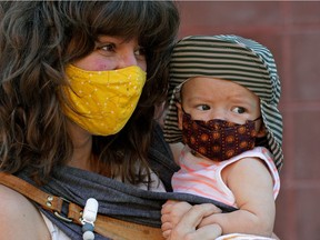 Tessa Stamp and her four-month-old baby Brome Stameny wear face coverings while strolling in Edmonton's Old Strathcona district on Thursday July 8, 2021 during the COVID-19 pandemic.