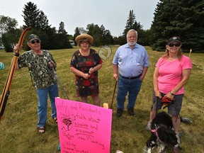 Displaying some of the activities done in the park, from left, Garry Trottier, Nancy Byway, John Thompson and Elaine Nystrom, are some members of a coalition of Idylwylde community members opposing the city's plan to add 18 trees to this pocket park in the community.