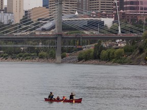 A family canoes on the North Saskatchewan River in Edmonton, on Wednesday, July 21, 2021. On Thursday, TransAlta is releasing water from the Bighorn Dam spillway that flows into the North Saskatchewan River near Nordegg leading to higher river levels than normally seen this time of year.