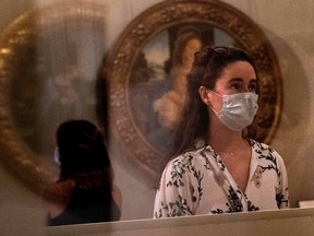 Visitors wearing a face mask view a room at the Galleria Borghese museum in Rome on May 19, 2020.